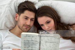 man n woman in bed w book